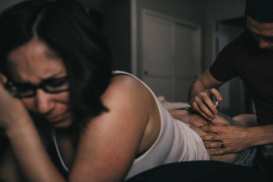 Husband injecting intramuscular shot in wife's butt fertility