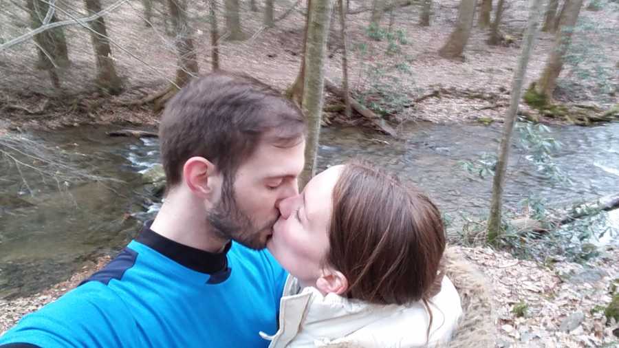 Married couple kiss in selfie with river in background