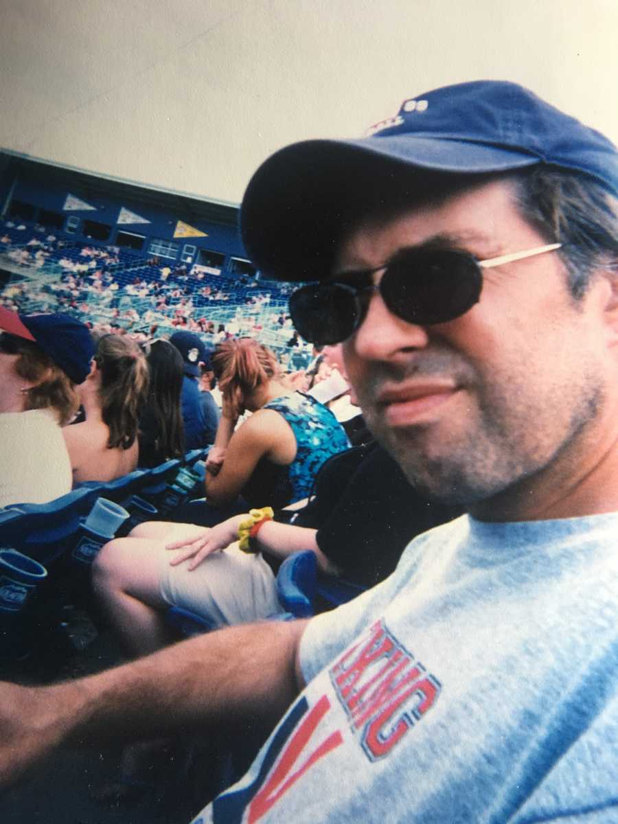 Man who will later in life struggle with dementia and parkinson's sitting in baseball stadium