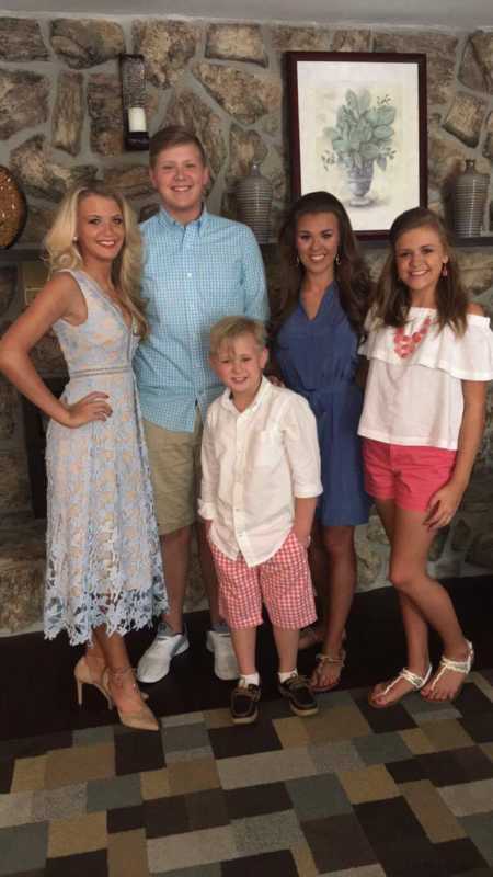 Teen with focal seizures stands smiling with four other siblings