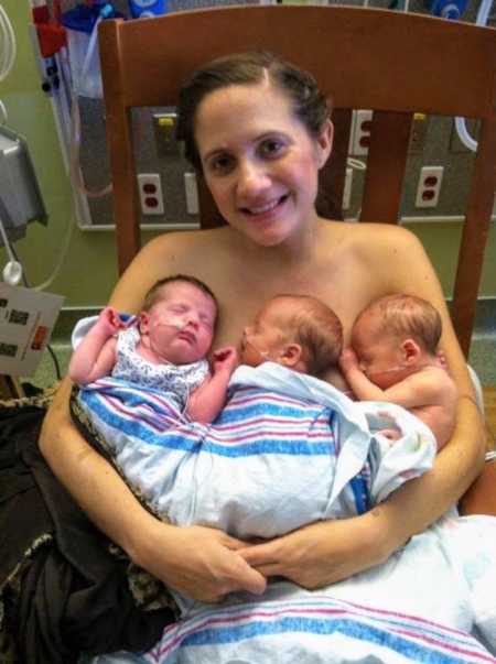 mom holding newborn triplets