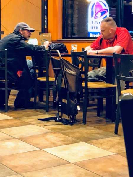 Man sitting at taco bell with disheveled man 