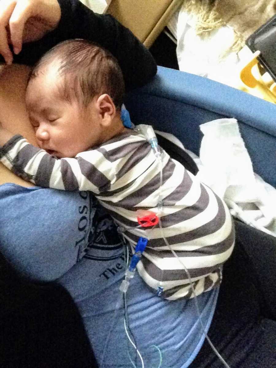 Baby with long term diagnosis with wires attached to his body sleeps on mothers chest