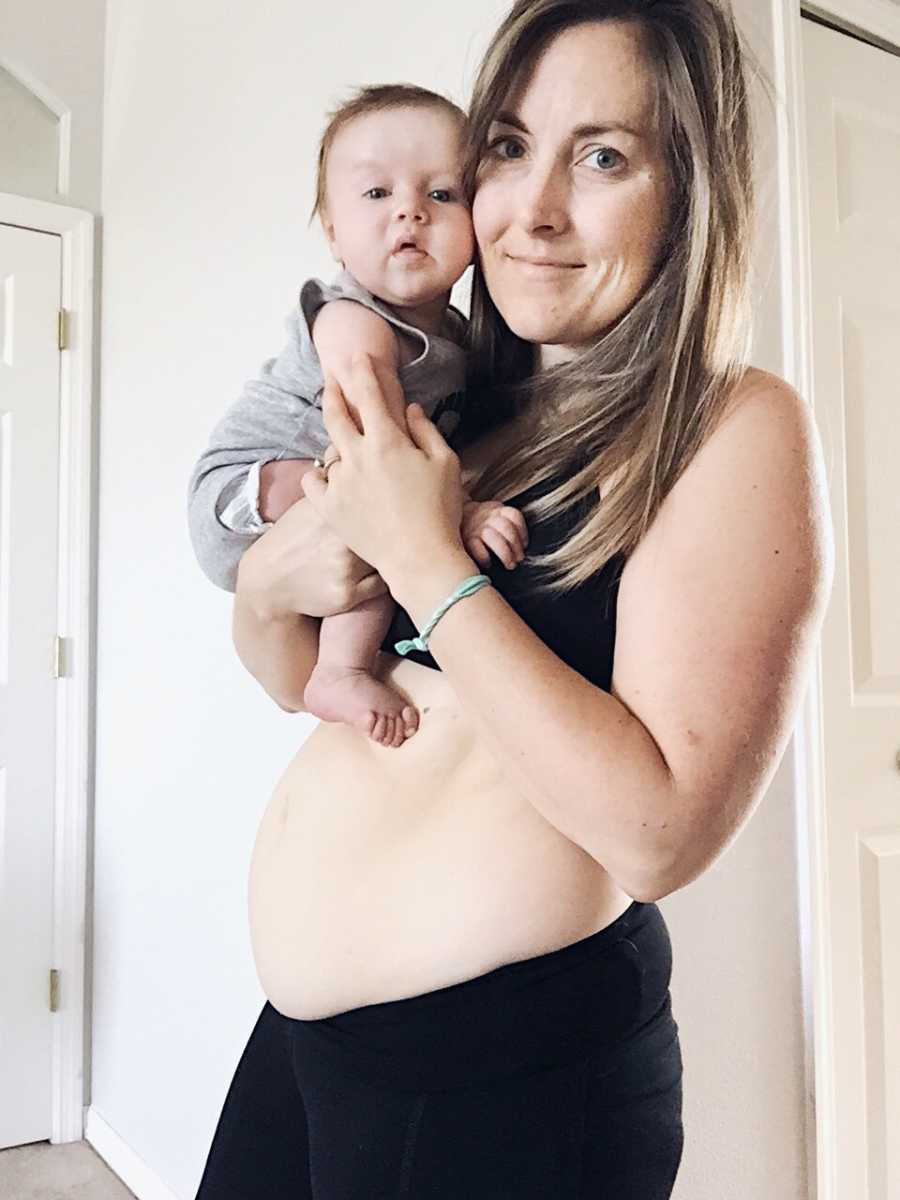 Woman who struggled with postpartum depression holds son in her arm with belly showing