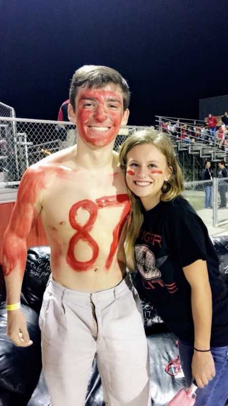 Boyfriend and girlfriend who got engaged on prom night standing in student section as freshman