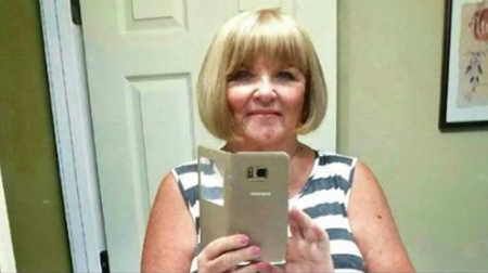 Woman who sent random person cookies smiling in mirror selfie