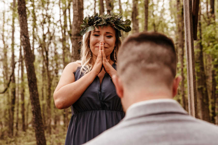 Girlfriend standing over boyfriend with hands over her mouth