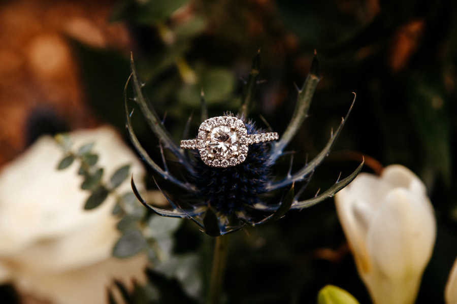 Close up of engagement ring sitting on flower