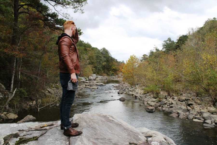 Man who turned to fitness to deal with depression standing on rock in river