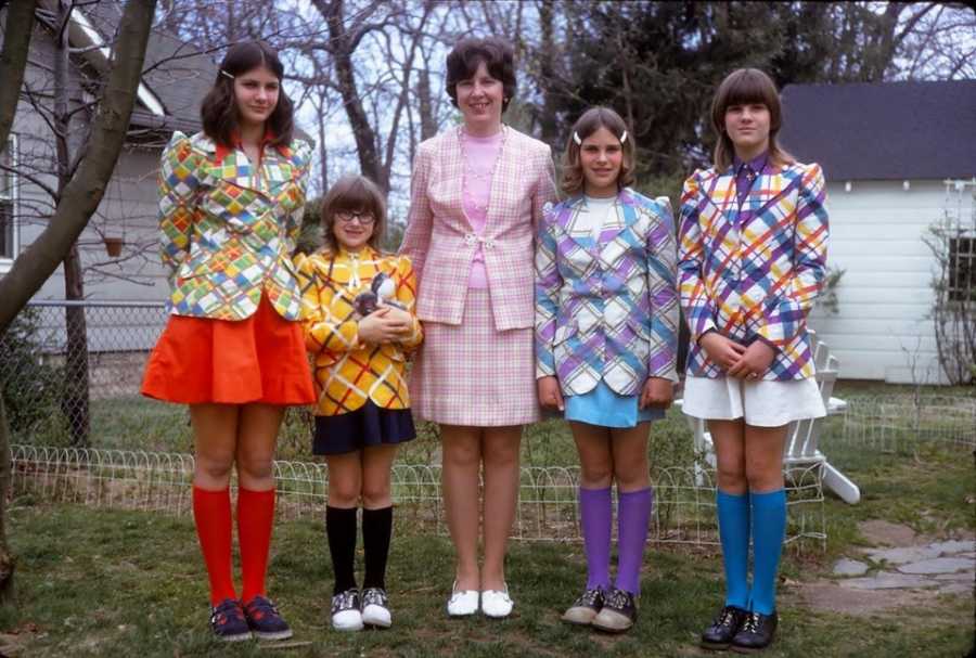 Mother standing beside four daughters in outfits that she sewed for them