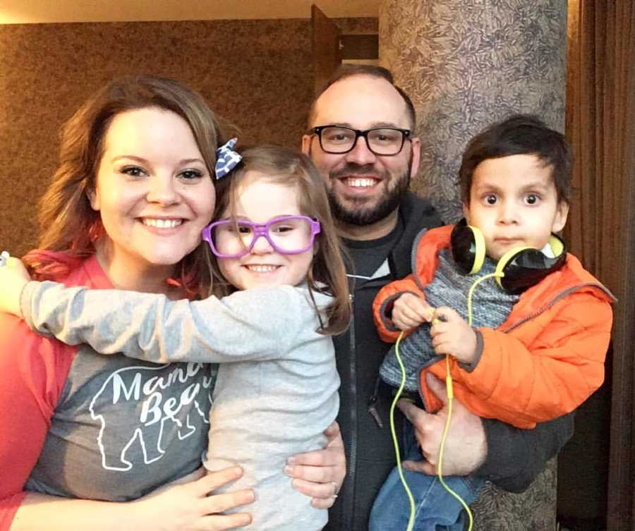 Mother holding birth daughter next to husband who holds adopted son who was born without esophagus 