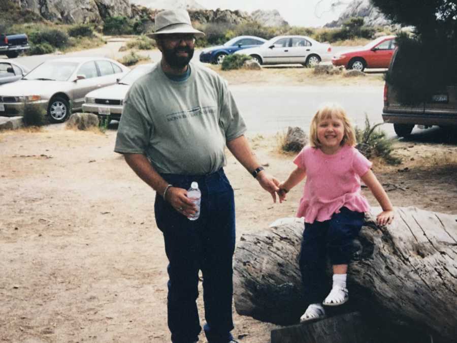 Man who will later suffer from dementia holding hands with daughter that sits on rock