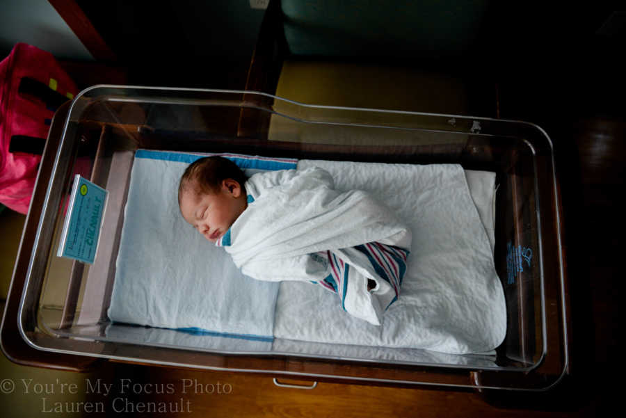 Aerial view of newborn lying in hospital swaddled in blanket