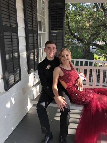 Boyfriend and girlfriend sit on porch swing after getting engaged on prom night