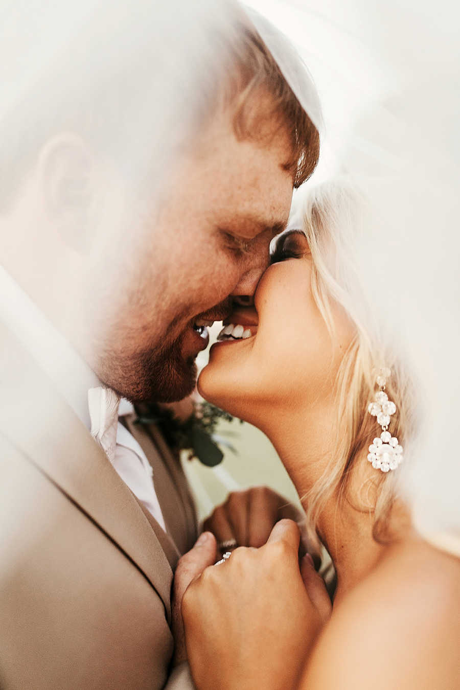 Close up of bride and groom smiling before they kiss