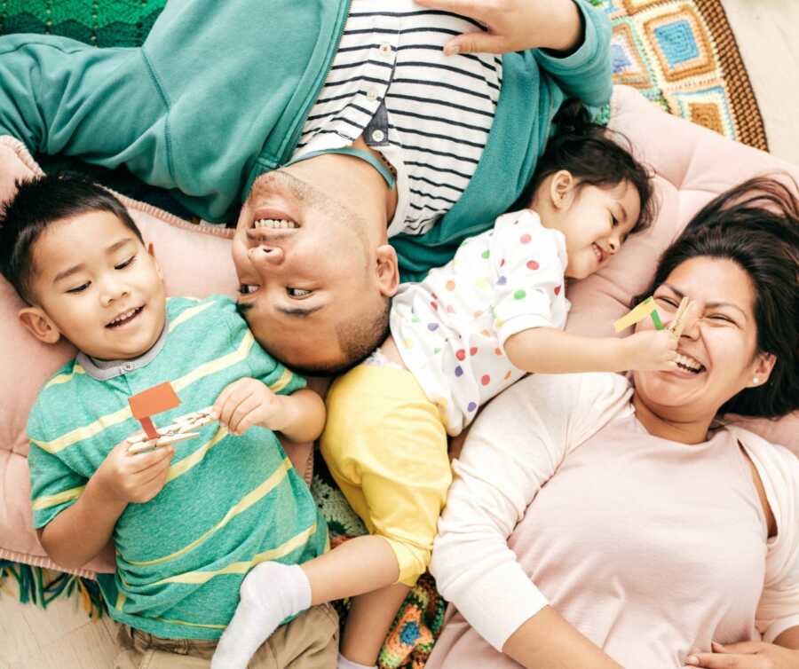 parents lying on floor bonding with toddlers