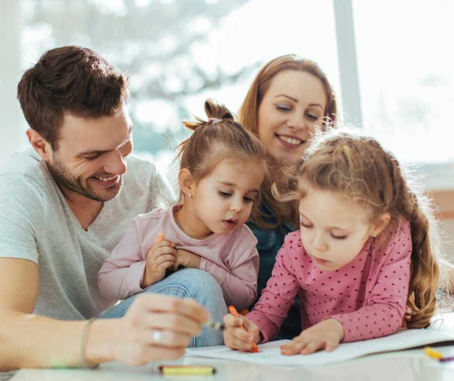 parents drawing with two little girls