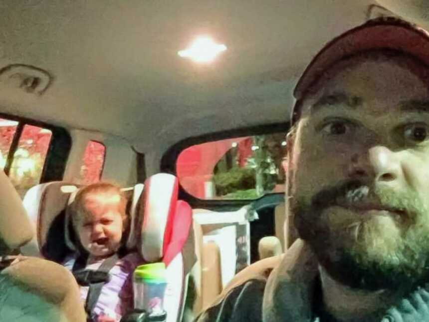 Dad in car with crying toddler in backseat