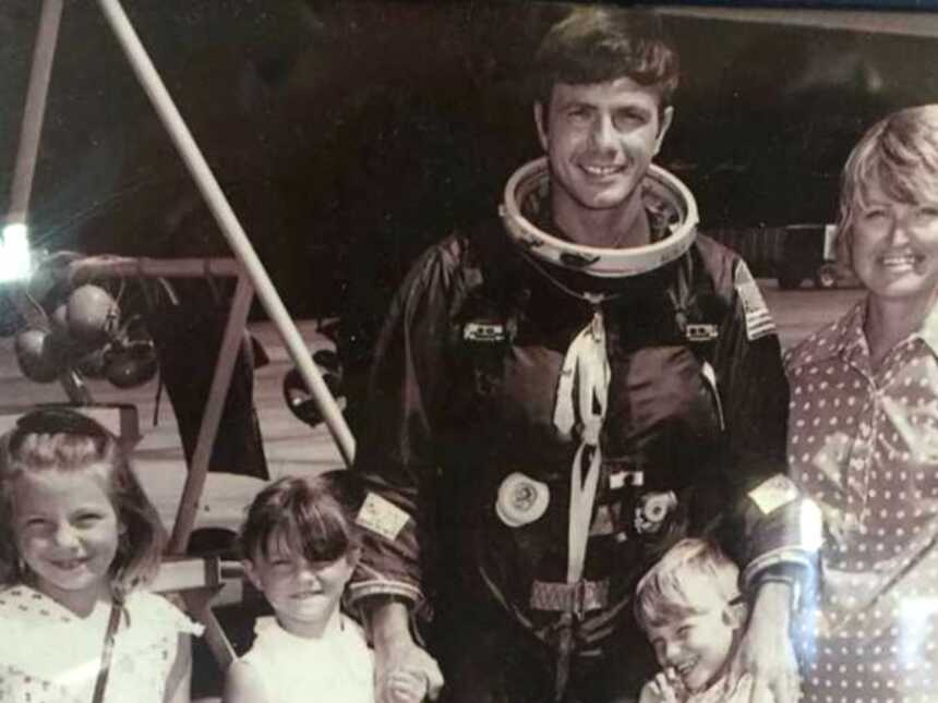 Vintage photo of dad in spacesuit next to wife and three kids