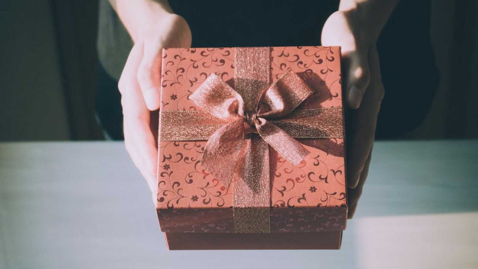 Woman holding red wedding gift box with bow