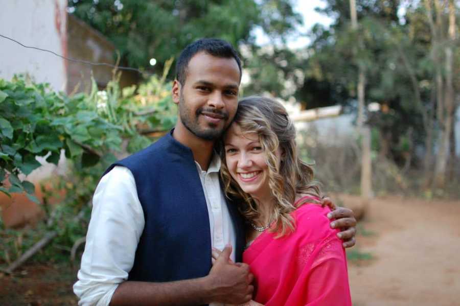 Newly engaged couple smiling as they hold each other tight