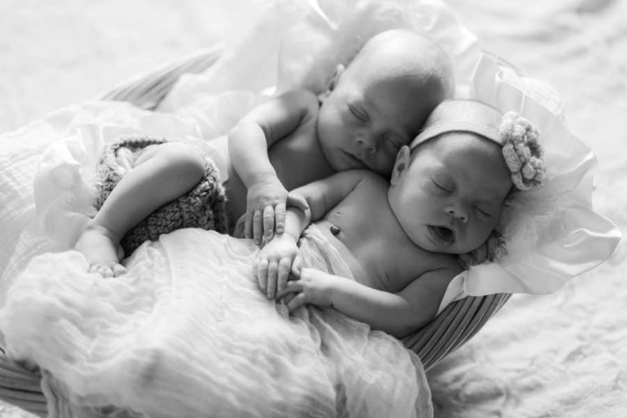 Newborn twins asleep together in basket who have since passed away