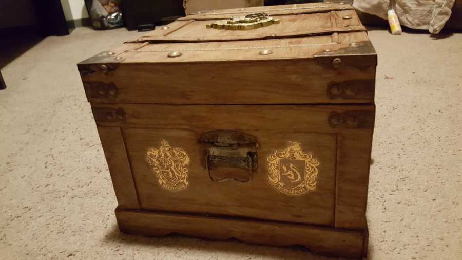 Gryffindor and Hufflepuff crests on side of trunk