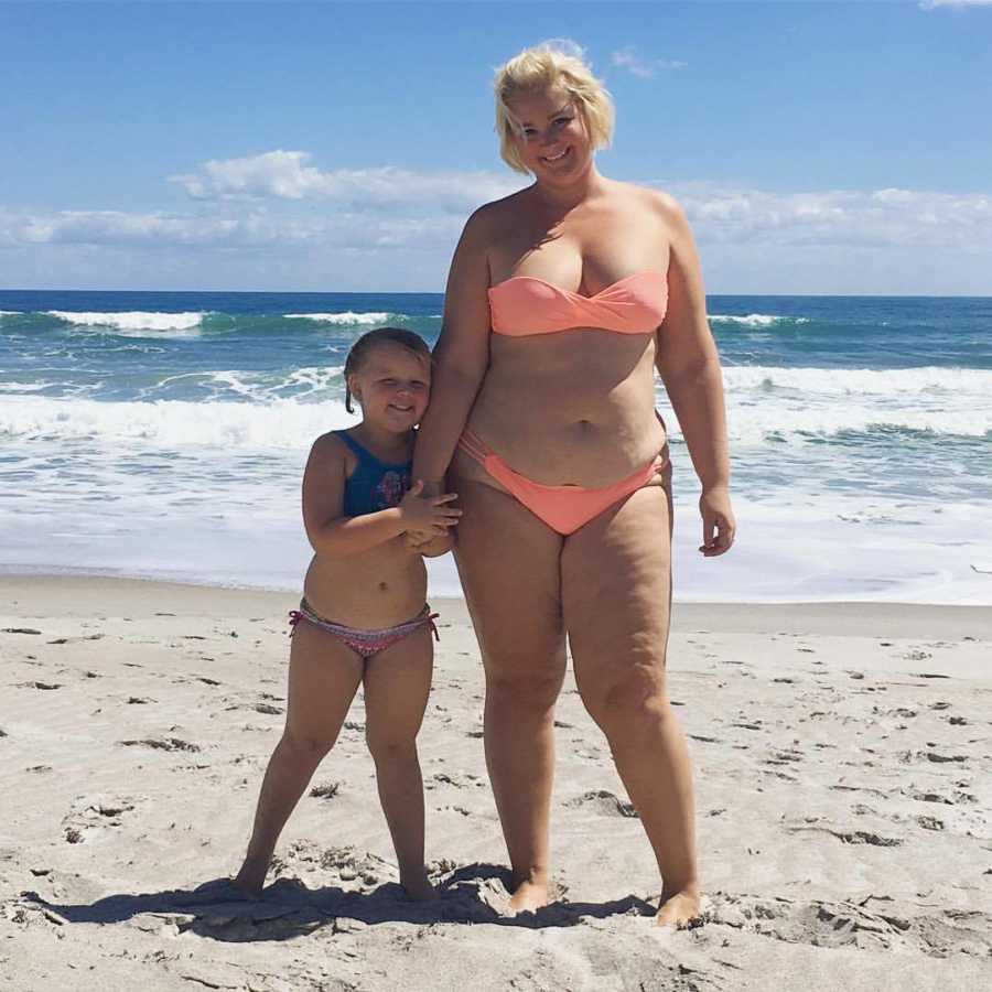 Woman who says mothers need to be careful about what they say around daughters standing on beach with daughter 