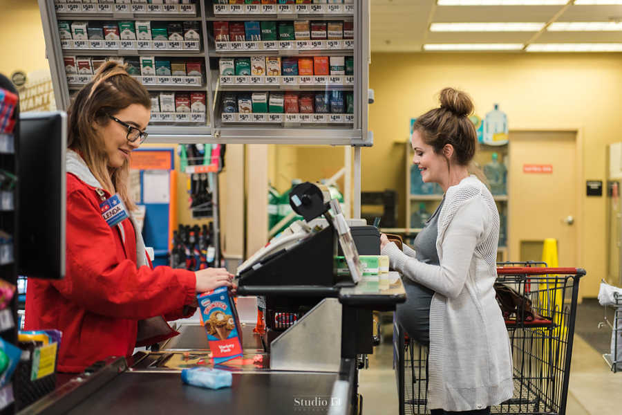 Pregnant woman checking out at grocery store