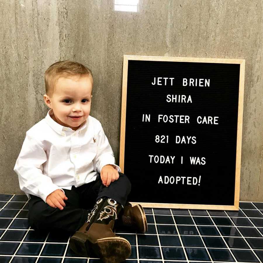Adopted boy recovered from meth withdrawals sits by sign saying, "In foster care 821 days today I was adopted"