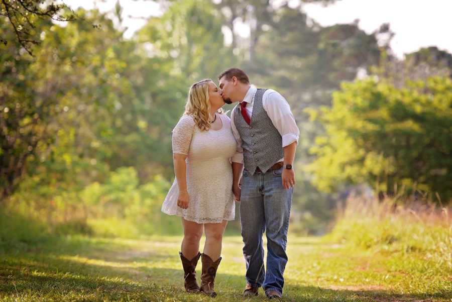 Couple who had fertility trouble walk hand in hand kissing 