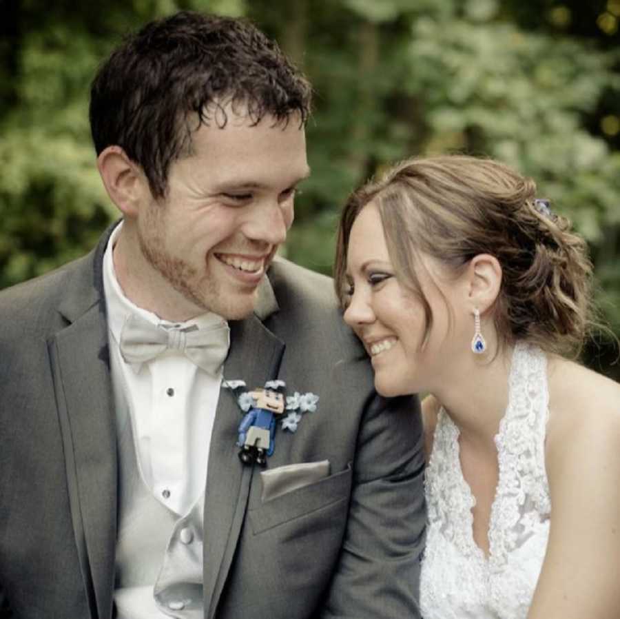 Bride and groom smiling while sitting next to each other