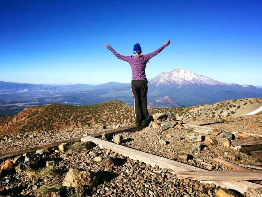 23 year old who had lung transplant standing on top of mountain