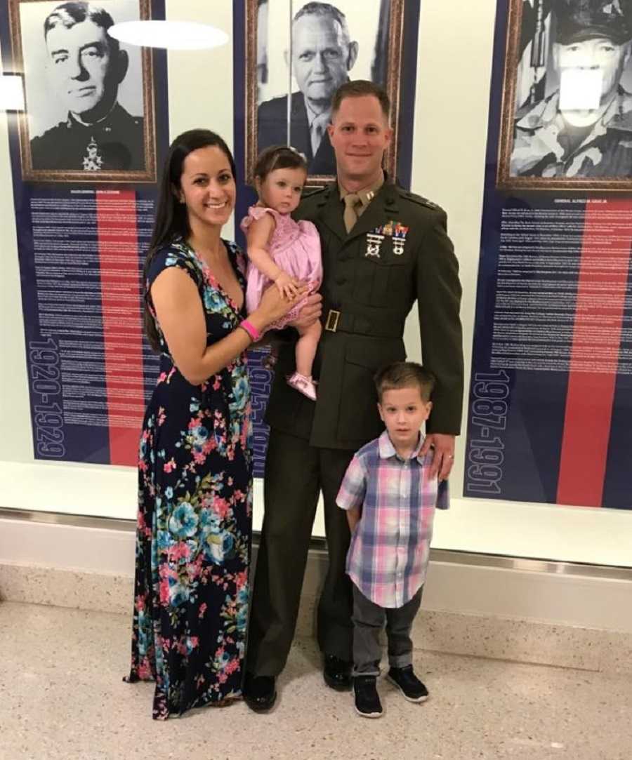 Mother and her military husband stand holding their youngest who will soon pass away and older son