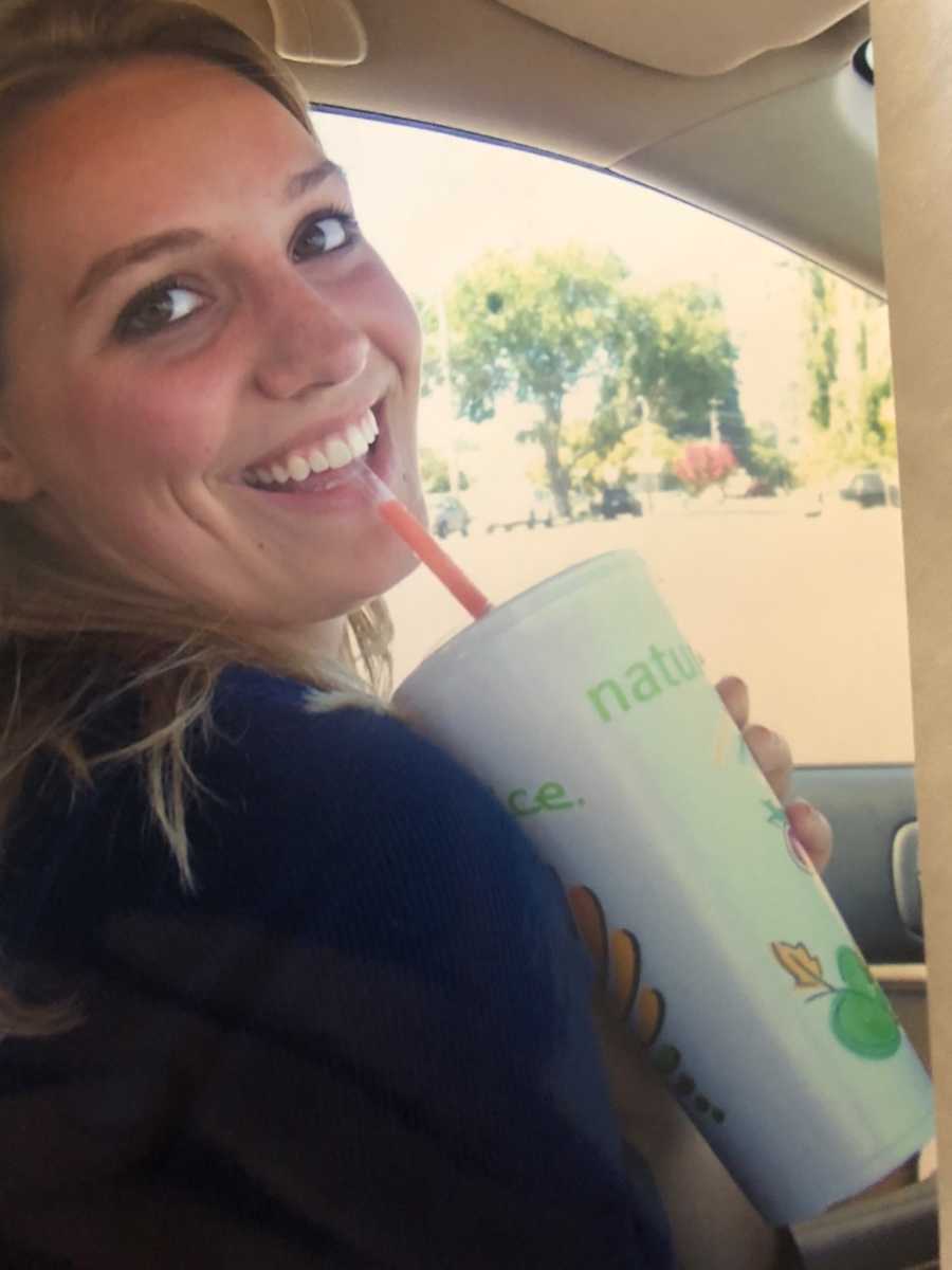 Teen with body image issues smiling in car while sipping out of straw