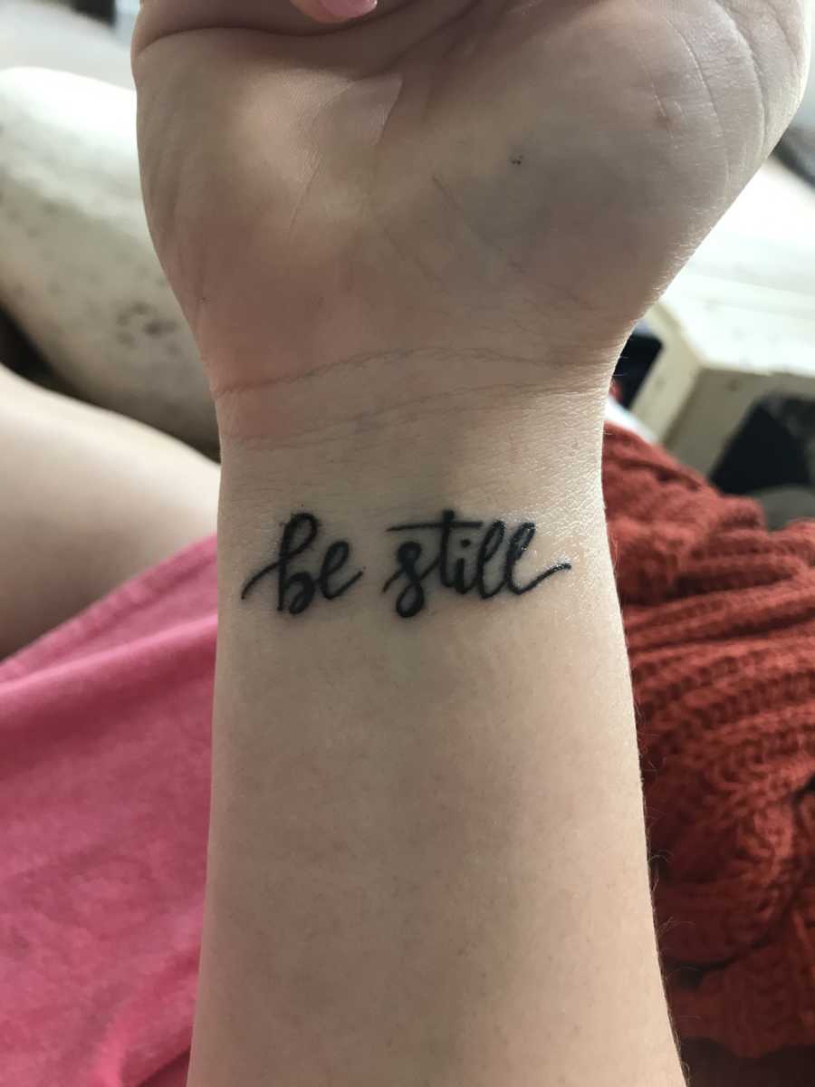 Tattoo on woman's wrist saying, "Be still" to keep her calm through fertility struggle