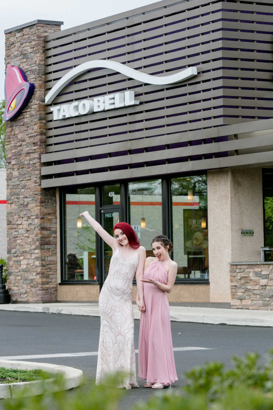 Girlfriends stand outside Taco Bell in their prom dresses