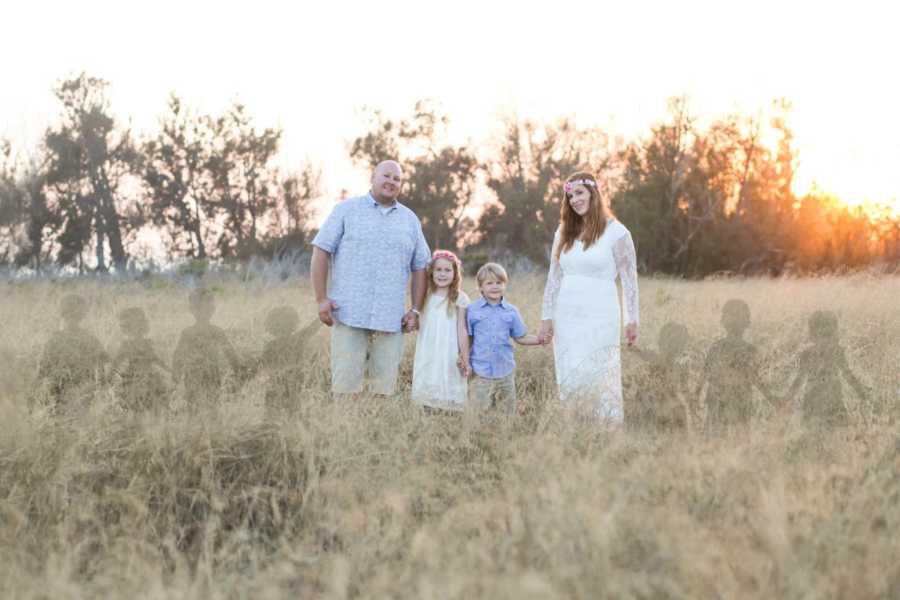 Mother and father stand with their two children and ghosts of seven children they had lost