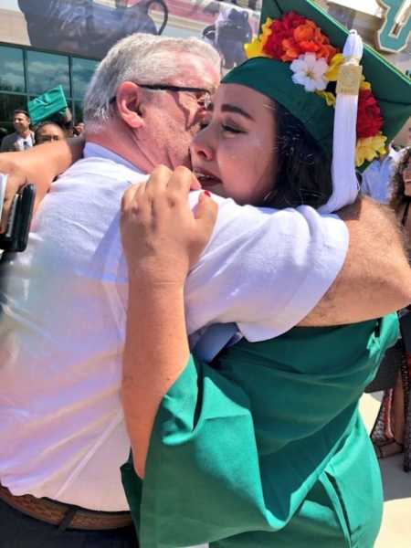 Young woman hugs father at graduation after her scholarships were taken away for being undocumented citizen