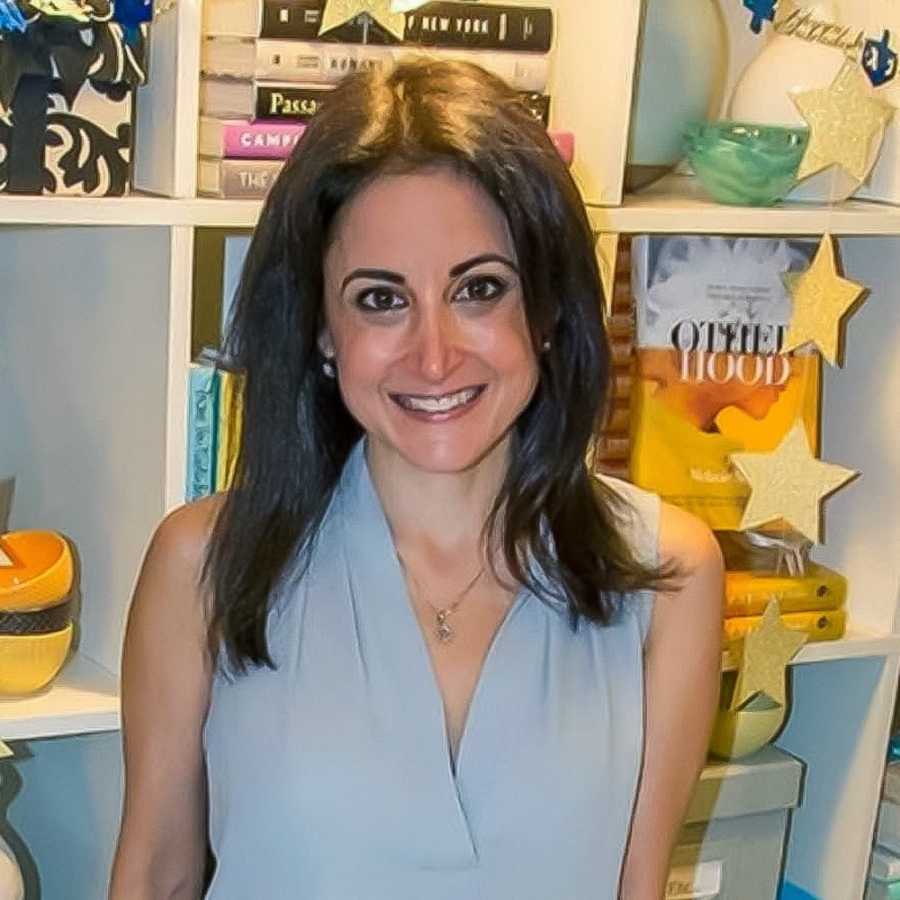 Woman who suffered from a miscarriage smiles in front of book shelf