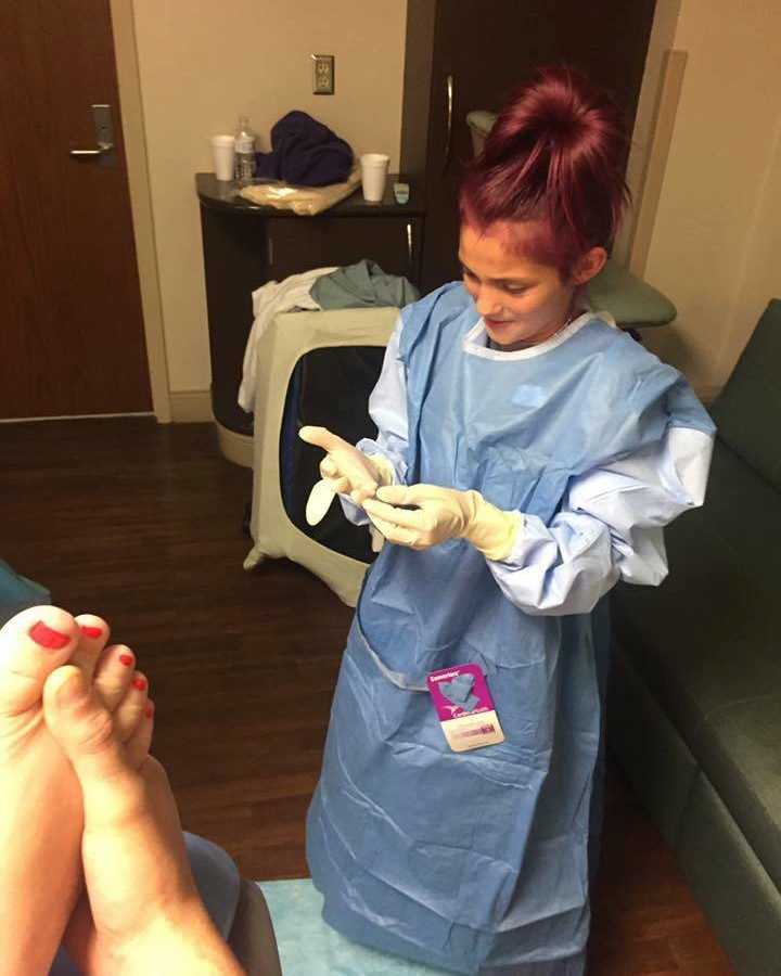 12 year old daughter in scrubs before mother gives birth