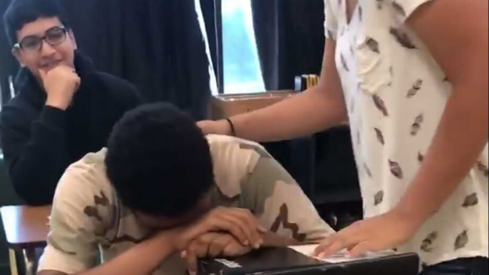 Student crying with head down on desk