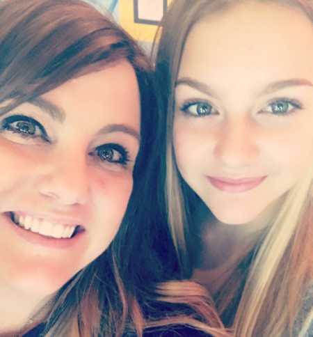 Mother smiles in selfie with teen daughter as she explains what things were like when she was younger