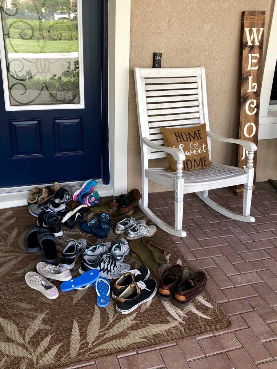 A porch in front of a house covered in children's shoes