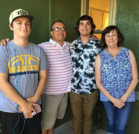 Man whose first wife passed away stands with new wife and their two teen sons