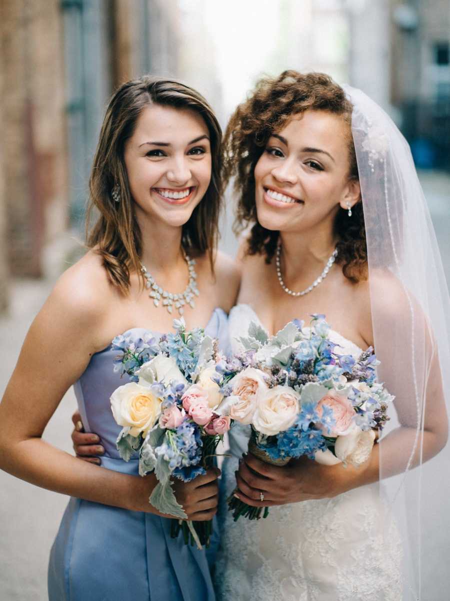 Bride and sister smile for a photo during wedding photos 