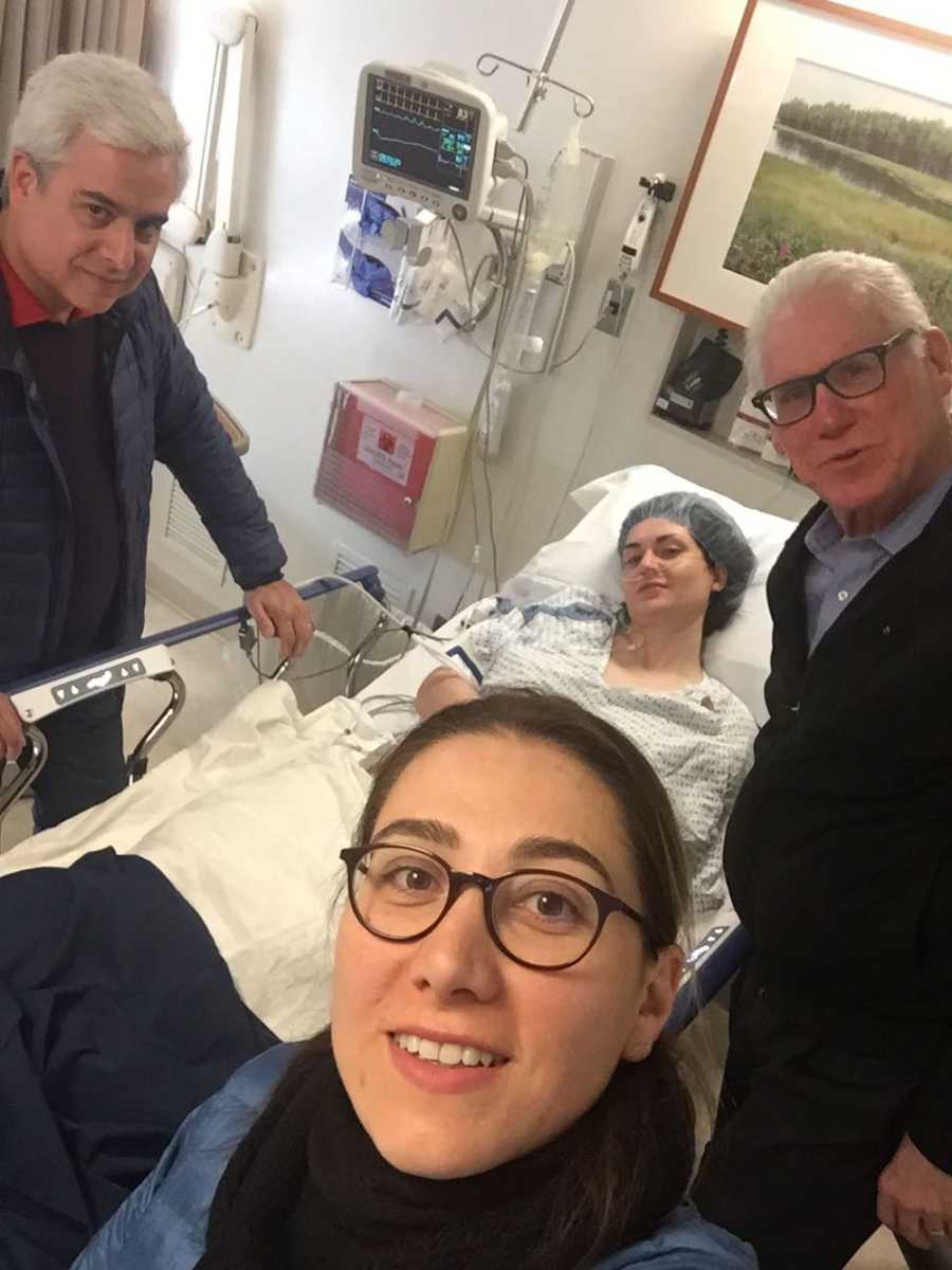 Family take selfie with woman in hospital bed, prepping for surgery