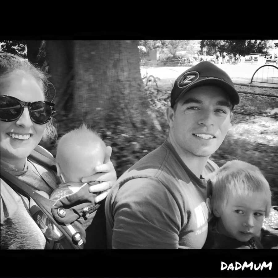 Family of four take a selfie together at a park