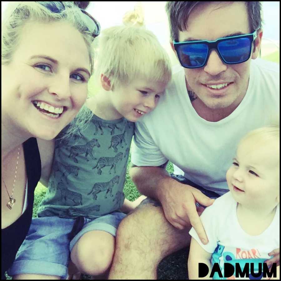 Family of four take candid photo while enjoying a day at the park together