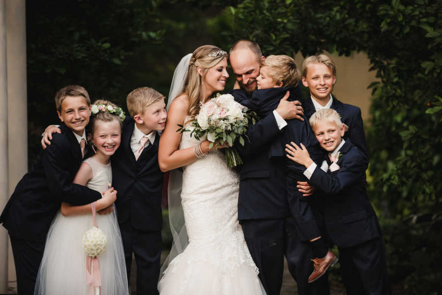 Blended family take group photo together on their parents' wedding day